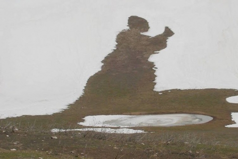 Un nomade in ginocchio mentre alza verso il cielo l’ostia della misericordia e recita: Laudato si’, mi’ Signore, per sora nostra matre Terra, la quale ne sustenta et governa, et produce diversi fructi con coloriti flori et herba. 