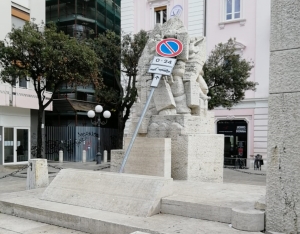 cartello poggiato su monumento che ha scatenato la consigliera comunale