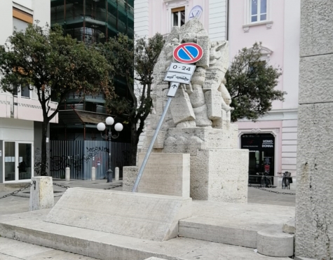 cartello poggiato su monumento che ha scatenato la consigliera comunale