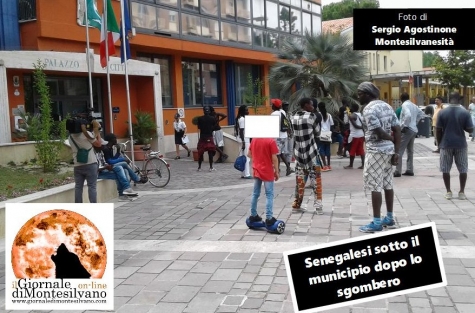 nell'immagine un ragazzino su hoverboard che guarda incuriosito un manifestante 