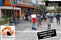 nell'immagine un ragazzino su hoverboard che guarda incuriosito un manifestante 