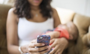 mamma che allatta con smarthphone