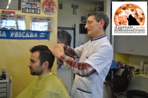 Aurelio Mingione mentre taglia i capelli al giovane Marco, cliente da ben 20 anni