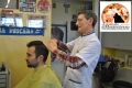 Aurelio Mingione mentre taglia i capelli al giovane Marco, cliente da ben 20 anni