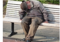 un signore senza fissa dimora costretto a dormire su una panchina.