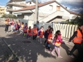Una mamma che con il sorriso sulle labbra accompagna i bambini a scuola